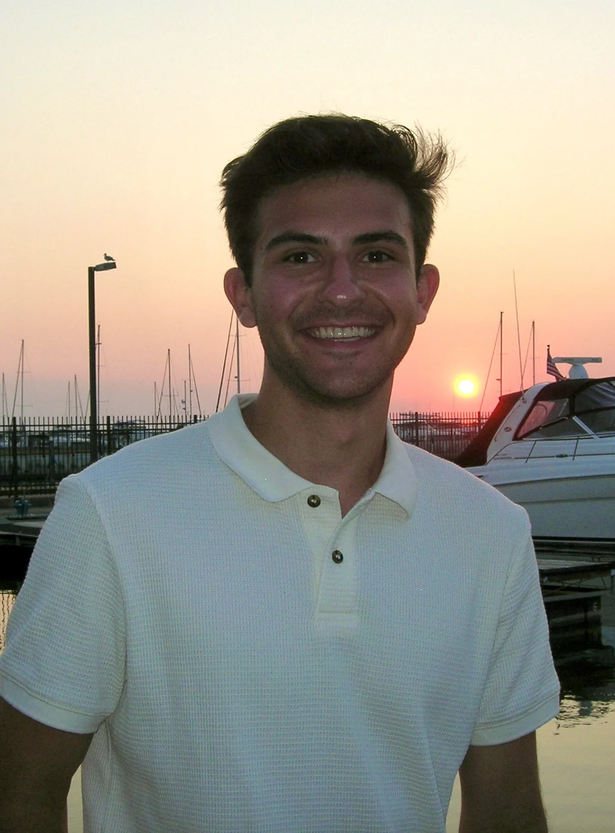 Carson smiling at a marina at sunset