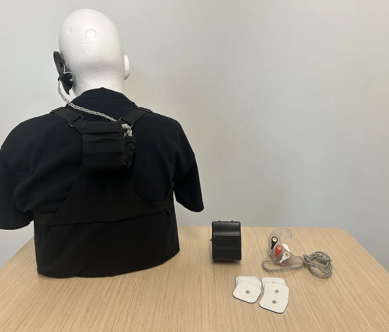 The finished wearable: behind-the-ear electrode holder, back-mounted processing unit, and harness
