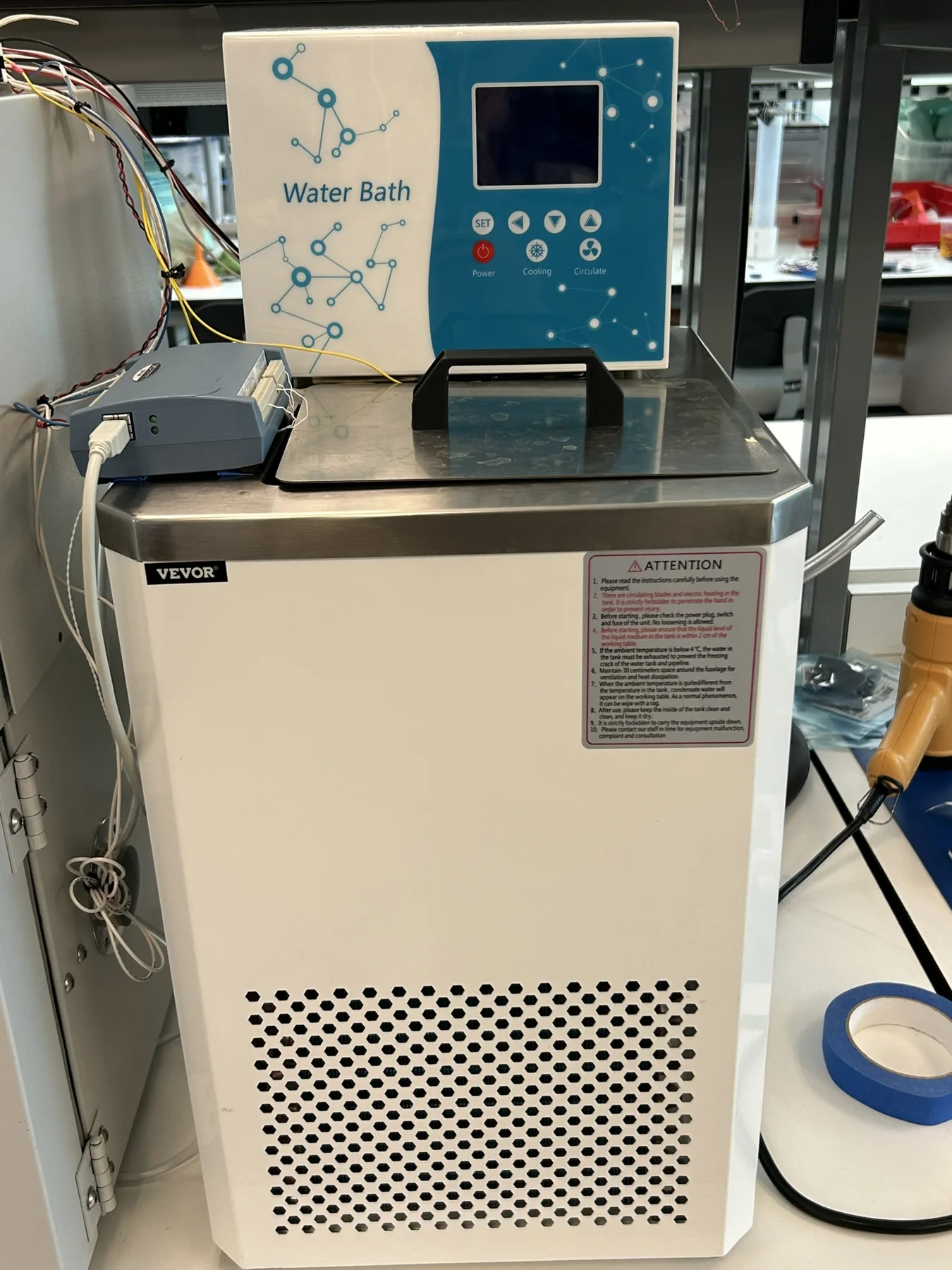The repurposed chiller with the USB DAQ on top (left), and inside the controller box, where solid-state relays switch the chiller's heating and cooling (right)
