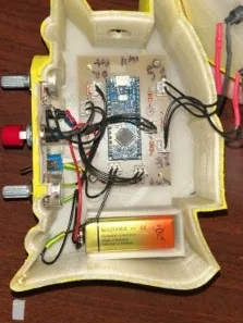 Inside: the PCB on heat-set inserts, the 9V battery in its slot, and the controls wired through the belt